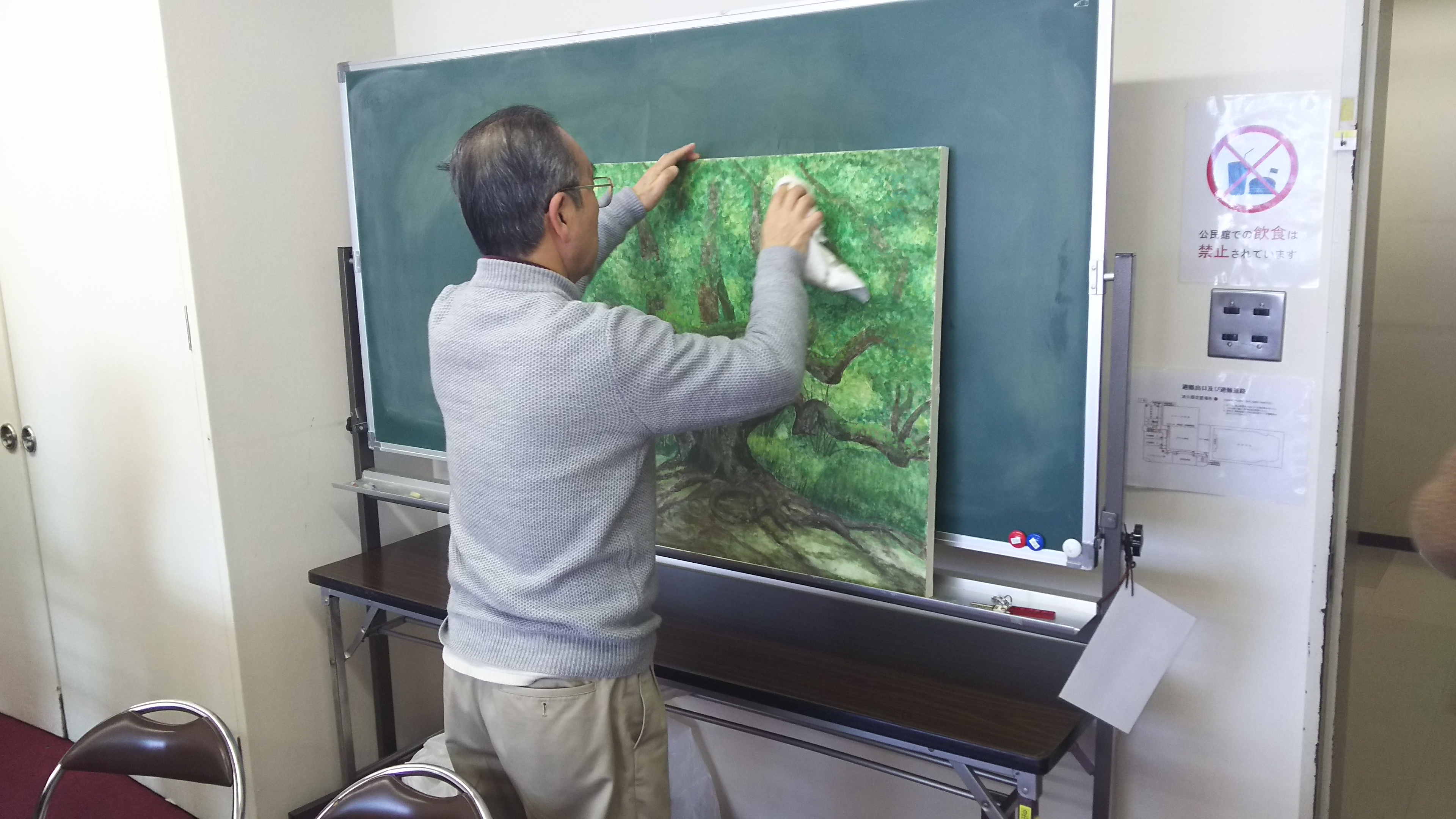 樹木の大作を描いている男性