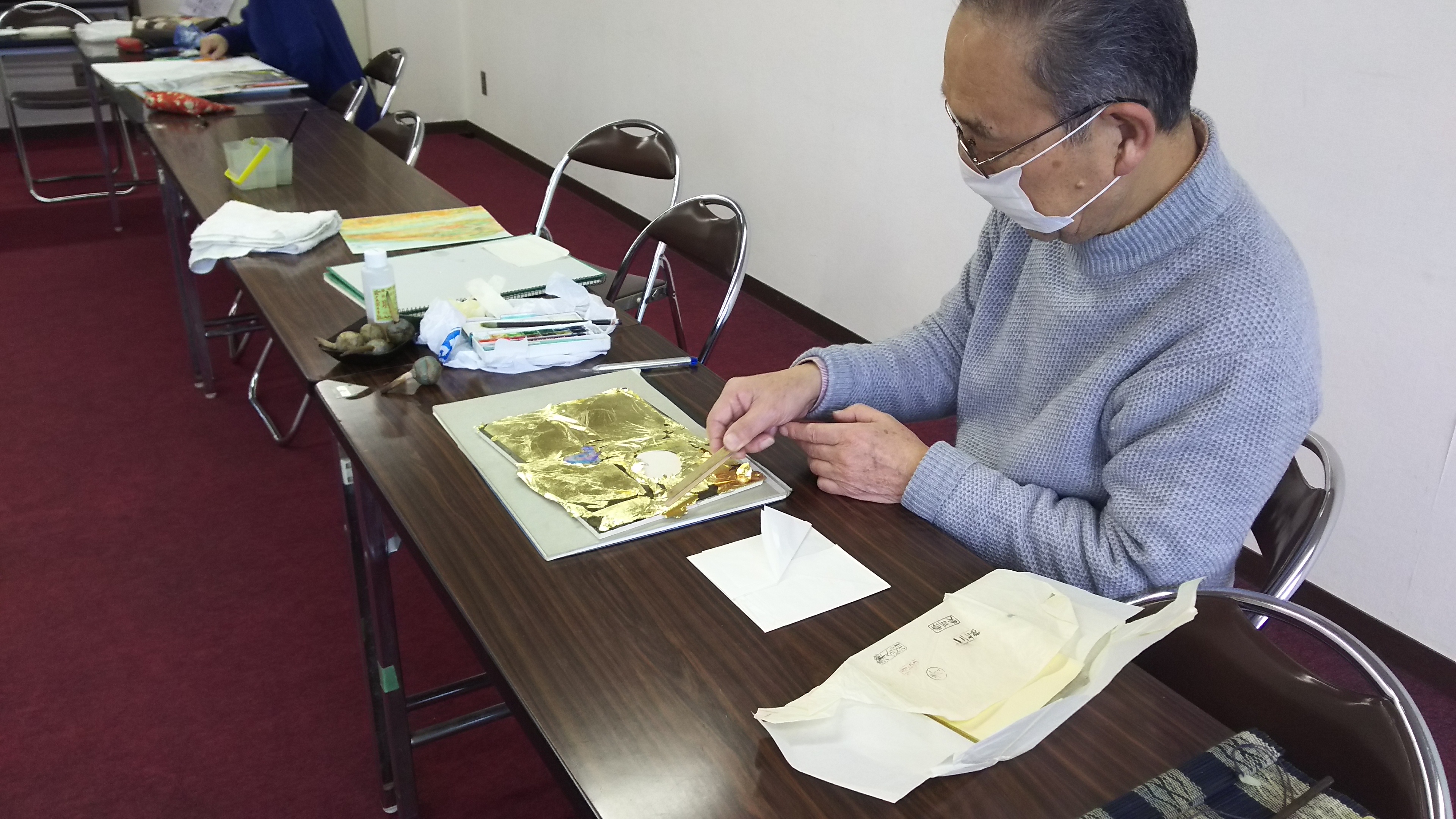 金箔を貼っている男性