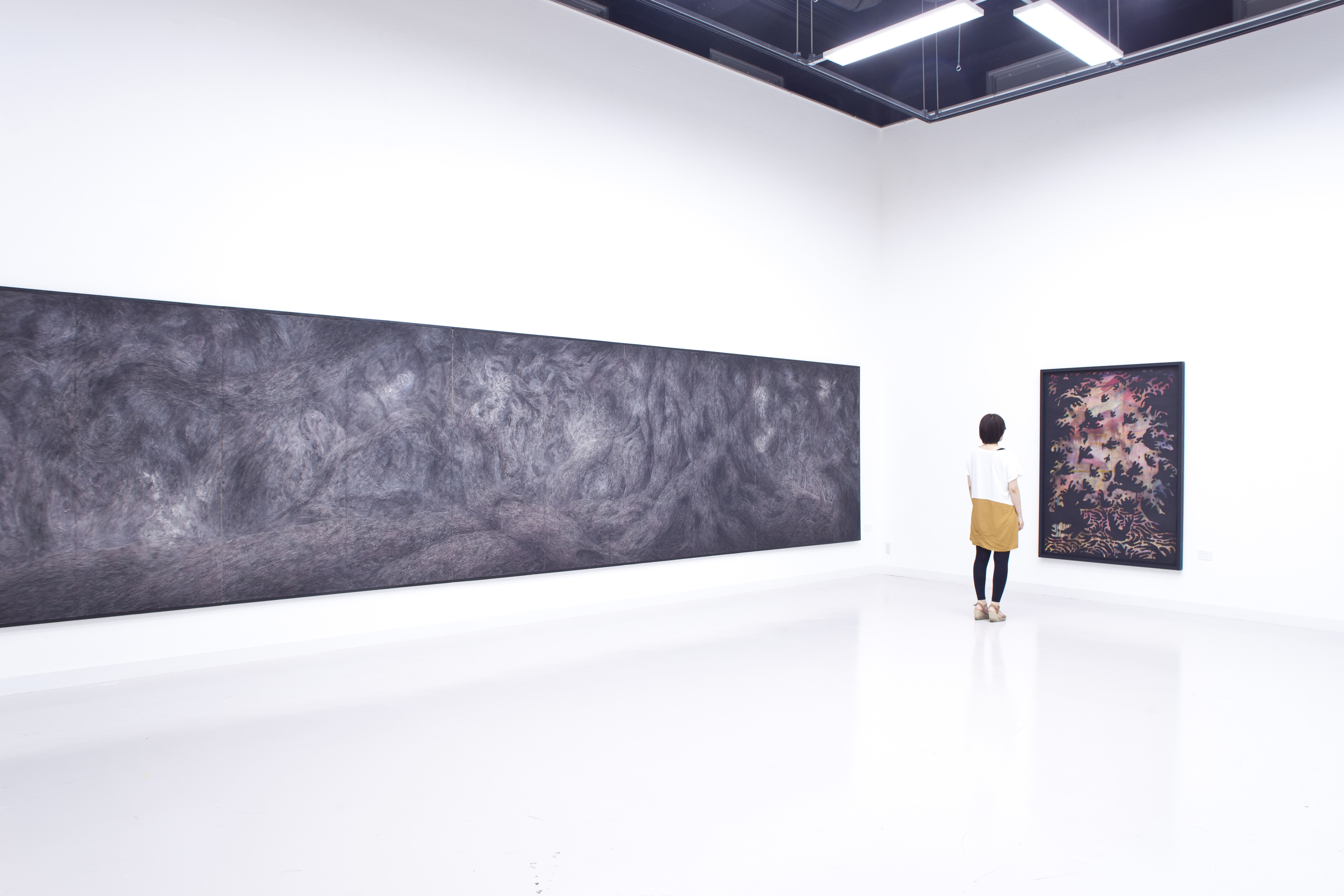 大きな絵の前に佇む女性